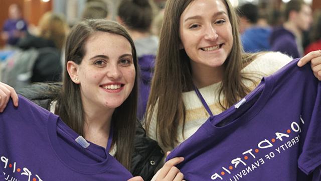 Students holding up Road Trip t-shirts